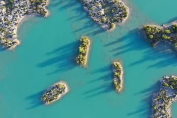 Islands in an turquoise quarry pond with trees
