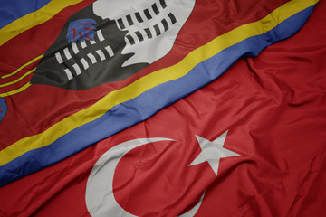 waving colorful flag of turkey and national flag of swaziland.