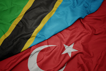 waving colorful flag of turkey and national flag of tanzania.