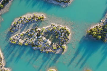 Islands in an turquoise quarry pond with trees