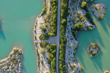 Islands in an turquoise quarry pond with trees