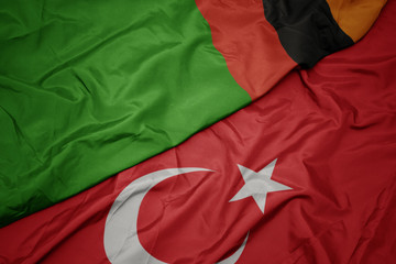 waving colorful flag of turkey and national flag of zambia.