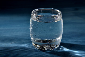 Frost-covered glass of water on a wooden table