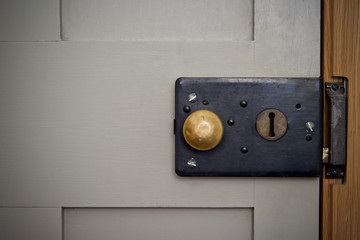 Vintage Victorian rim lock on a grey door with brass knob