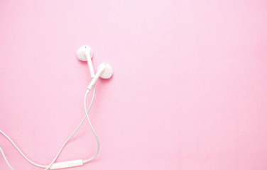 white headphones on pink background with copy space