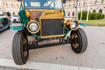 Retro car parked in European city street, waiting for tourists