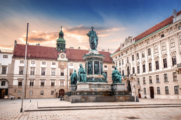 Fototapeta na wymiar Sunset cityscape view with Statue of Kaiser Franz I in the courtyard of imperial Hofburg Palace in Vienna, Austria