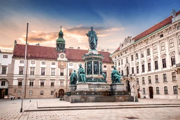 Fototapeten Sunset cityscape view with Statue of Kaiser Franz I in the courtyard of imperial Hofburg Palace in Vienna, Austria © EdNurg