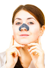 Woman applying pore strips on nose