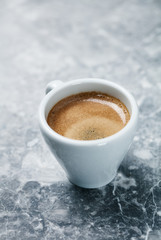 Cup of coffee on bright stone background. Copy space