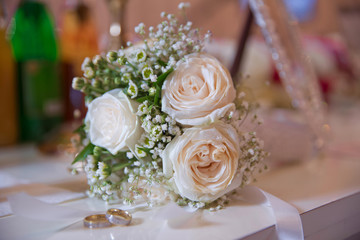 Wedding rigs in front of a wedding bouquet. Shallow depth of field