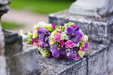Beautiful bridal bouquet with freesias, pink roses and violet orchids. Traditional bride's accessory and symbol of love and marriage.