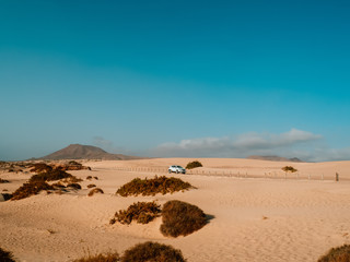 Fototapeta na wymiar All terrain car parked on the beach sand. Voyage concept.