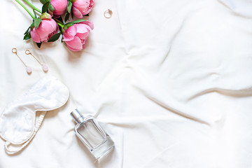 Concept lifestyle flat lay on the white blanket with peony flowers. Copy space
