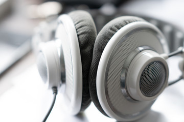 White headphone is lying on the table in bright back light