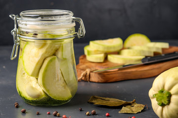 Fermented zucchini in jar on a dark background, Harvesting vegetables for healthy food, copy space,...