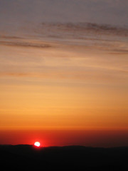 Sunrise in the mountains. Sunset sky. Nature photography orange clouds and sun over hill