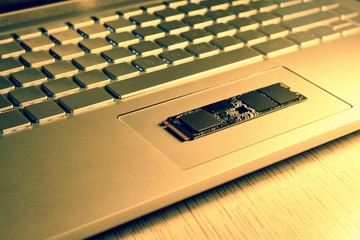 Chip SSD-drive in the center of the laptop trackpad. Details of the chip in sharpness. In the light...