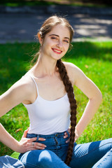 Portrait of a young beautiful brunette woman in on summer park background