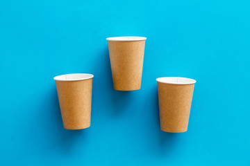 Paper cups for coffee to go on blue background top view