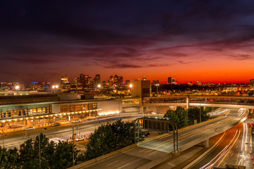 Colorful sunset sky over Boston downtown and Logan airport with cars passing by - obrazy, fototapety, plakaty