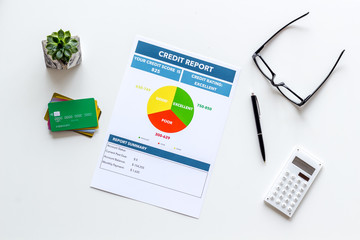 credit report with credit cards and calculator, glasses on banker work place white background top...