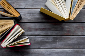 Books on library desk on wooden background top view space for text