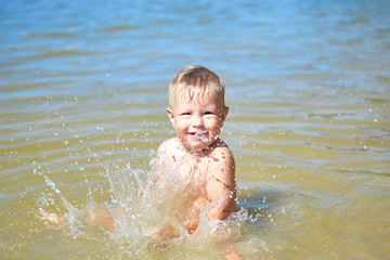 Fototapeta na wymiar Cheerful child bathes in water
