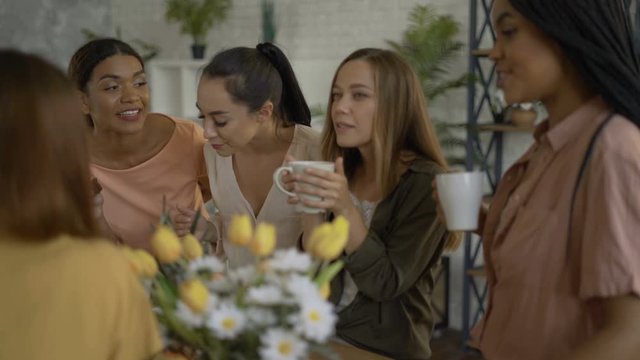 5 mixed race girlfriends drink tea / coffee in the kitchen. women having fun and chatting 4K