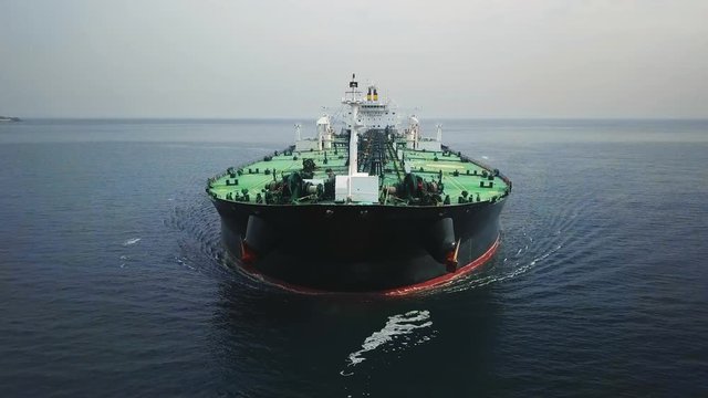 Bow and front deck of a tanker ship underway in the open sea. Aerial frontal view as crude oil tanker ploughs through waters at sea. Full loaded vessel moves at calm waters. Close up of bulbous bow br