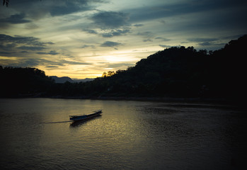 Fototapeta na wymiar sunset on the river with a boat in southeast of Asia 