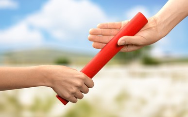 Close-up of relay baton being passed