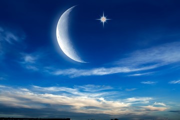 Beautiful dark fluffy cloudy sky with sun rays . Crescent moon with beautiful sunset background . Generous Ramadan . New moon. Prayer time.  © yaalan