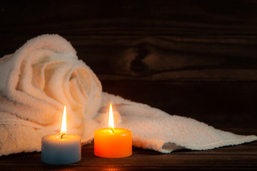 Fototapeta na wymiar two candles, towel and wood