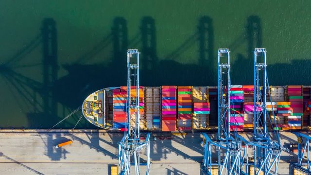 Container ship loading and unloading in deep sea port, Aerial top view of business logistic import and  export freight  transportation by container ship in open sea.