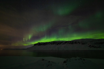 Fototapeta na wymiar Bright and wavy aurora of the fjord