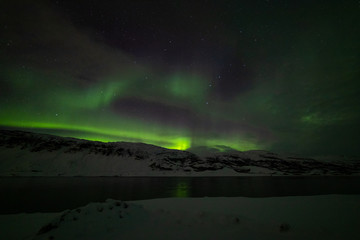 Fototapeta na wymiar Spreading aurora over the fjord