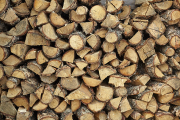 Dry firewood in a pile for furnace kindling firewood texture. Firewood stack. Staple of biomass arranged firewood