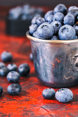 Bowl of organic blueberries on red background