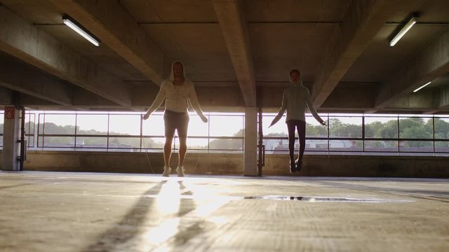 Father and child skipping in the sunlight together with jump ropes, in slow motion