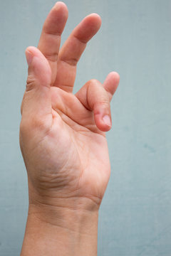 Trigger Finger lock on ring finger of woman's side left hand, Suffering from pain, On Blue-grey colour background,  Close up & Macro shot, Office syndrome, Health care concept
