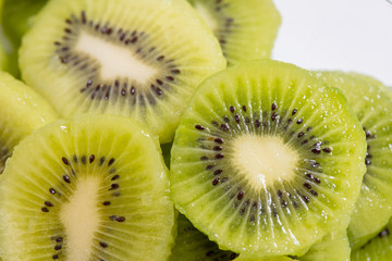 Many kiwi slices are placed in a glass crisper. Kiwifruit slices without peel.
