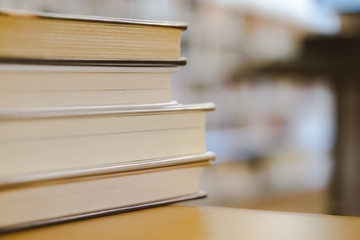 Book in library with old open textbook, stack piles of literature text archive on reading desk, and aisle of bookshelves in school study class room background for academic education learning concept