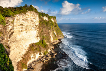 Fototapeta na wymiar Bali Cliffs in Indonesia with Waves Crashing Against Rocks