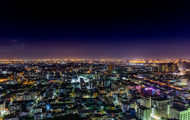 Bangkok cityscape at nighttime with street lights and dark sky.