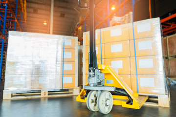 hand pallet truck with stacked of package boxes on wooden pallet, cargo export for transportation at distribution warehouse.