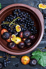 Freshly picked autumn fruits. Black grapes and figs on dark table wooden table