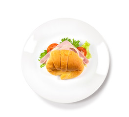 Big croissant with green salad and pork meat on isolate white background. Tasty croissant Food photo. Healthy food concept.