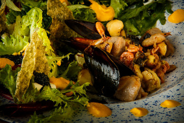 Fototapeta na wymiar macro view on tasty appetizer of assorted seafood and salad leaves