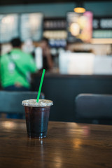Cup of coffee ice americano on wooden table in coffee shop 